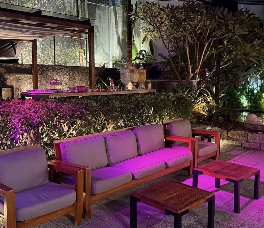 Lounge com sofás no jardim iluminado à noite
